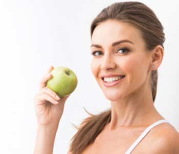 Smiling pretty girl holding an apple
